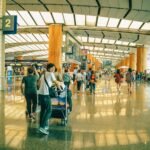 Travelers bustling through Singapore Changi Airport terminal, highlighting the dynamic and vibrant atmosphere of international travel.